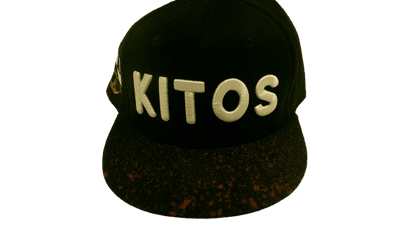 BLACK SPLASH SNAPBACK featuring a black kitos hat with a custom brim and gold accents.